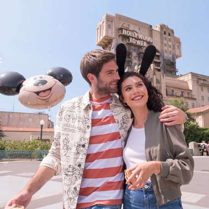 Giovane coppia sorridente nei viali <span class="text-nowrap">di Disneyland® Paris</span>