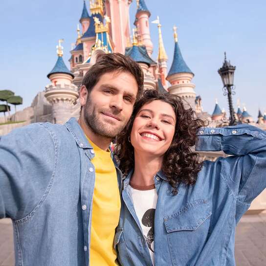 Giobane coppia si fa un selfie con il castello di Disneyland® sullo sfondo
